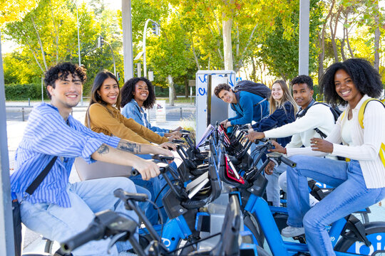 Diverse friends enjoying bike sharing service in city