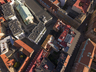 Aerial view of a dense urban landscape with buildings displaying a mix of red tile and dark rooftops, creating a textured mosaic of architectural styles, Malmo, Skane County, Sweden.