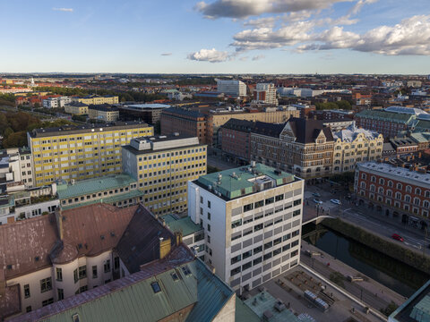 Aerial view of buildings basking in warm sunlight, shadows playing across rooftops and canals near Stortorget, Malmo, Skane County, Sweden.