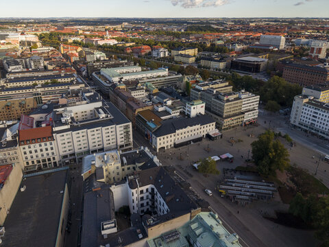 Aerial view of Gustav Adolfs torg bathed in golden light, revealing the intricate architecture and bustling city life below, Malmo, Sweden.