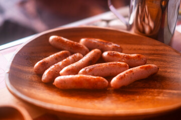 焼いたウインナー、木の皿
