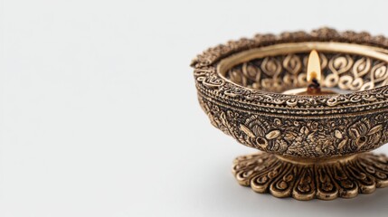 A beautifully crafted brass diya featuring intricate designs against a clean white background, perfect for festive occasions or cultural themes, with ample space for text on the right.