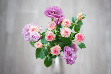 やわらかな光に包まれたピンクと紫のバラの花束