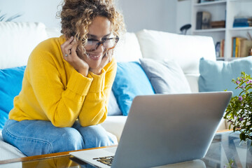Woman working on a laptop at home, focused and productive while sitting on sofa or at table, symbol...