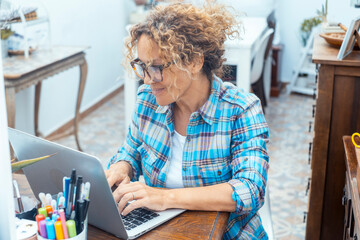 Woman working on a laptop at home, focused and productive while sitting on sofa or at table, symbol...