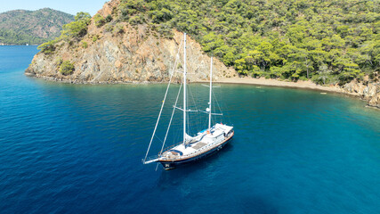Obraz premium A breathtaking summer day with a gulet ship floating gracefully on turquoise waters.