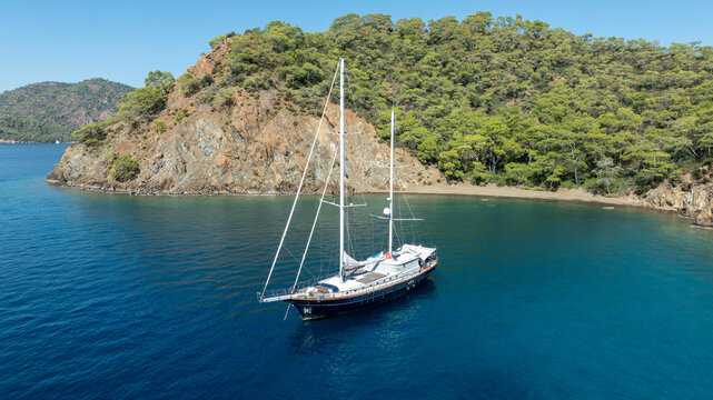 A breathtaking summer day with a gulet ship floating gracefully on turquoise waters.
