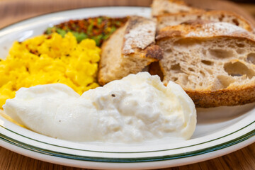 brunch dish with avocado, egg scramble, bread and yogurt