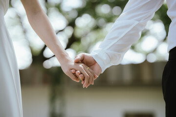 A close-up of a couple holding hands, symbolizing love, care, trust, and a romantic relationship with warmth and connection.