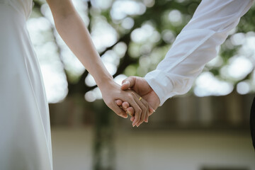 A close-up of a couple holding hands, symbolizing love, care, trust, and a romantic relationship with warmth and connection.