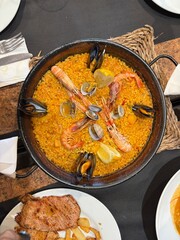 Traditional Spanish Seafood Paella with Mussels, Prawns and Lemon Served in Cast Iron Pan.