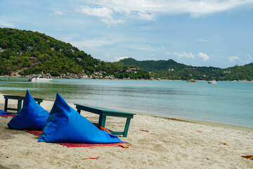 Relaxing beach scene with beach umbrella shading comfortable beds , cabana, water, sunshade. Beautiful beach and white sand with beach chair. Asian tropical beach paradise in Thailand