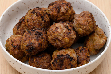 Baked beef and pork cutlets made of red meat on a collective plate,