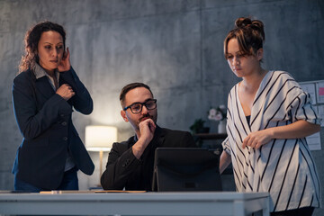 Business team working late analyzing data on tablet in office meeting