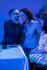 Friends gossiping during a party in blue light