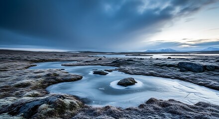 An icy tundra landscape under a dark, stormy sky, featuring a frozen stream winding through mossy, frost-covered ground with distant, snowy mountains.