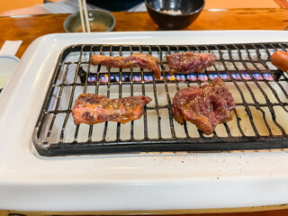 焼肉屋の風景。焼いてる牛カルビ肉と牛ロース肉・