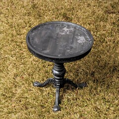 A small, round black table with classic carved legs. The surface appears slightly worn, giving it a vintage feel.