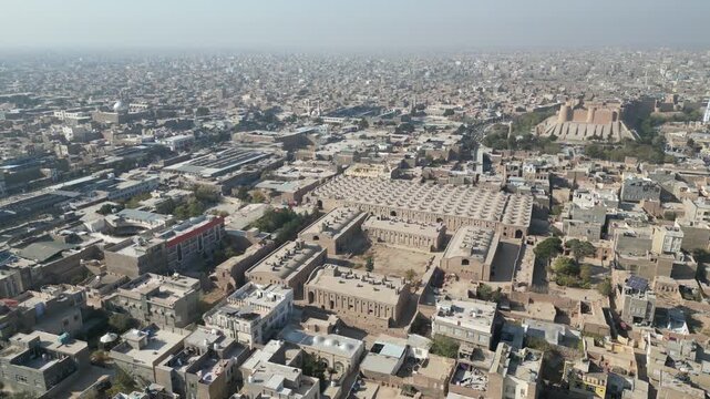 Aerial establishing drone fly above Herat city in Afghanistan, mosque citadel university and town streets