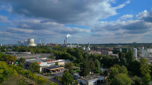 Industrial landscape with factories, a large power plant, and storage tanks bordering river in berlin germany. Gorgeous aerial view flight overflight flyover drone