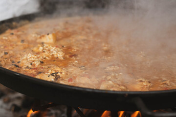 Traditional Spanish rice dish cooking on fire