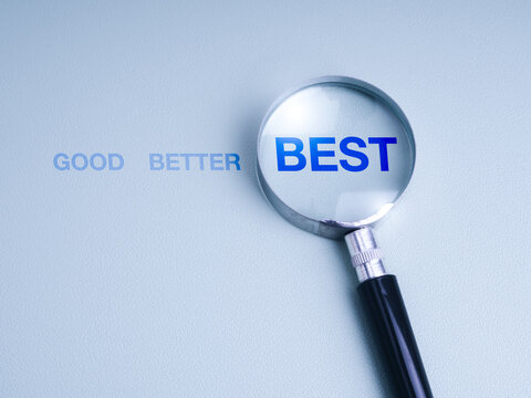 Magnifying glass highlighting the word "BEST" from a sequence "GOOD, BETTER, BEST" on blue background, symbolizing excellence, improvement, strategic planning, work development, and decision making.