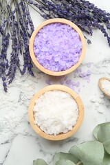 Sea salt, lavender and eucalyptus leaves on white marble table, flat lay