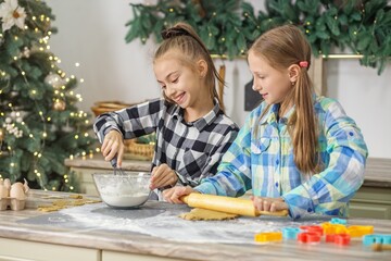 Girls mixing and rolling cookie dough