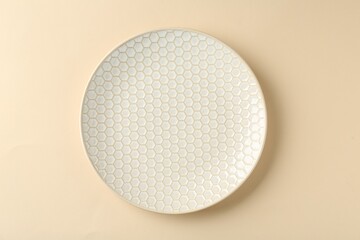 Stylish ceramic plate on beige background, top view