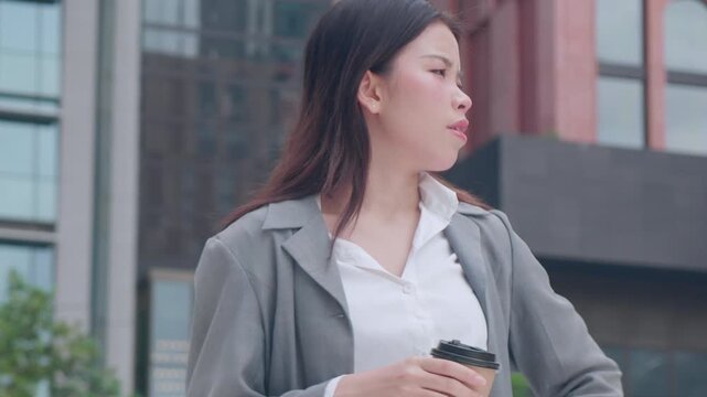 Young asian businesswoman checking time on smartwatch in urban, business woman impatient for appointment with anxiety and urgency in corporate career, female worried about schedule and deadline.