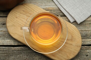 Aromatic black tea in glass cup on wooden table, top view