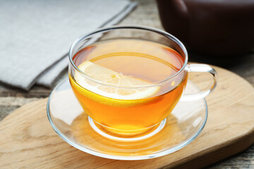 Aromatic black tea with lemon in glass cup on table, closeup