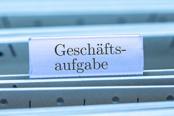 Schild mit der Aufschrift GESCHÄFTSAUFGABE an einem Hängemappenregister