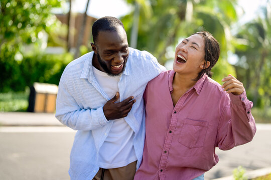 Diverse couple enjoying vacation, embracing travel, relaxation, and happiness in tropical paradise - Powered by Adobe