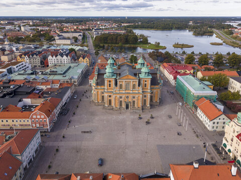 Aerial view of Kalmar Cathedral's baroque architecture stands majestically on Stortorget square, framed by the city's rooftops and the tranquil waters in the background, Kalmar, Kalmar County, Sweden.