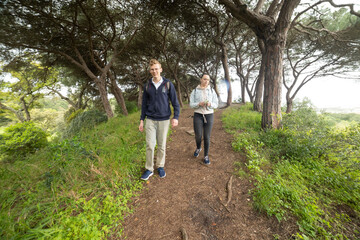 Obraz premium Young couple walking tranquil path in green forest