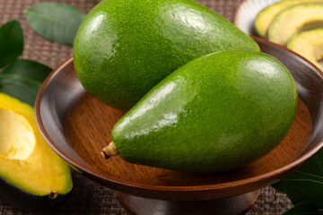 Fresh avocado with sliced and diced pieces over woven bamboo background