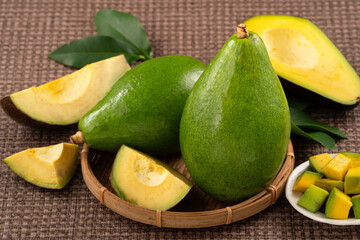 Fresh avocado with sliced and diced pieces over woven bamboo background