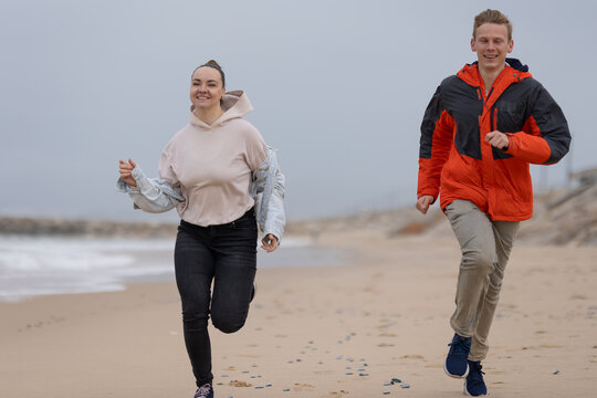 Young couple running on beach having fun