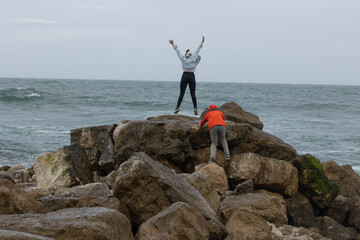 Young women finding joy and challenge on ocean rocks