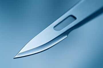 Obraz premium Close-up of a surgical scalpel blade with sharp precision edges, reflecting soft blue lighting, emphasizing sterile design and clinical accuracy.
