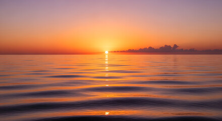 Naklejka premium A serene sunset over the ocean casting a golden light on the water surface creating a peaceful atmosphere