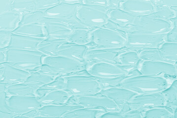 Texture of cosmetic gel with turquoise blue strokes as a background