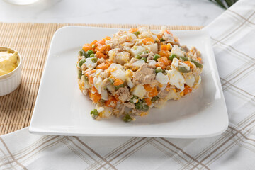 Traditional russian salad with tuna, eggs, and vegetables