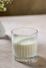 glass of fresh milk on beige breakfast table