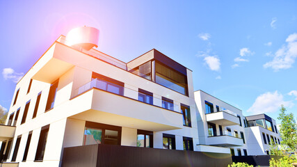 Modern luxury apartment building with balconies.The structure features a glass wall in front, showcasing contemporary architecture.