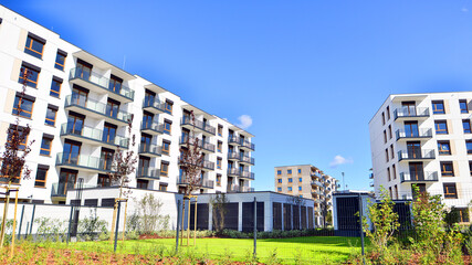 A residential building  by lush green trees and surrounded by  fresh vegetation on a clear sunny...