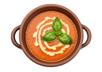 Isolated tomato soup in clay bowl garnished with cream and basil leaves, appetizing dish