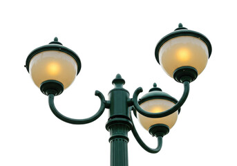 Isolated green ornamental street light with three glowing lamps, outdoors, public lighting