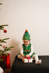 Toddler Girl Opening Christmas Gift by Tree